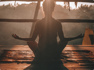 Person meditating outdoors at sunrise for inner peace and vitality